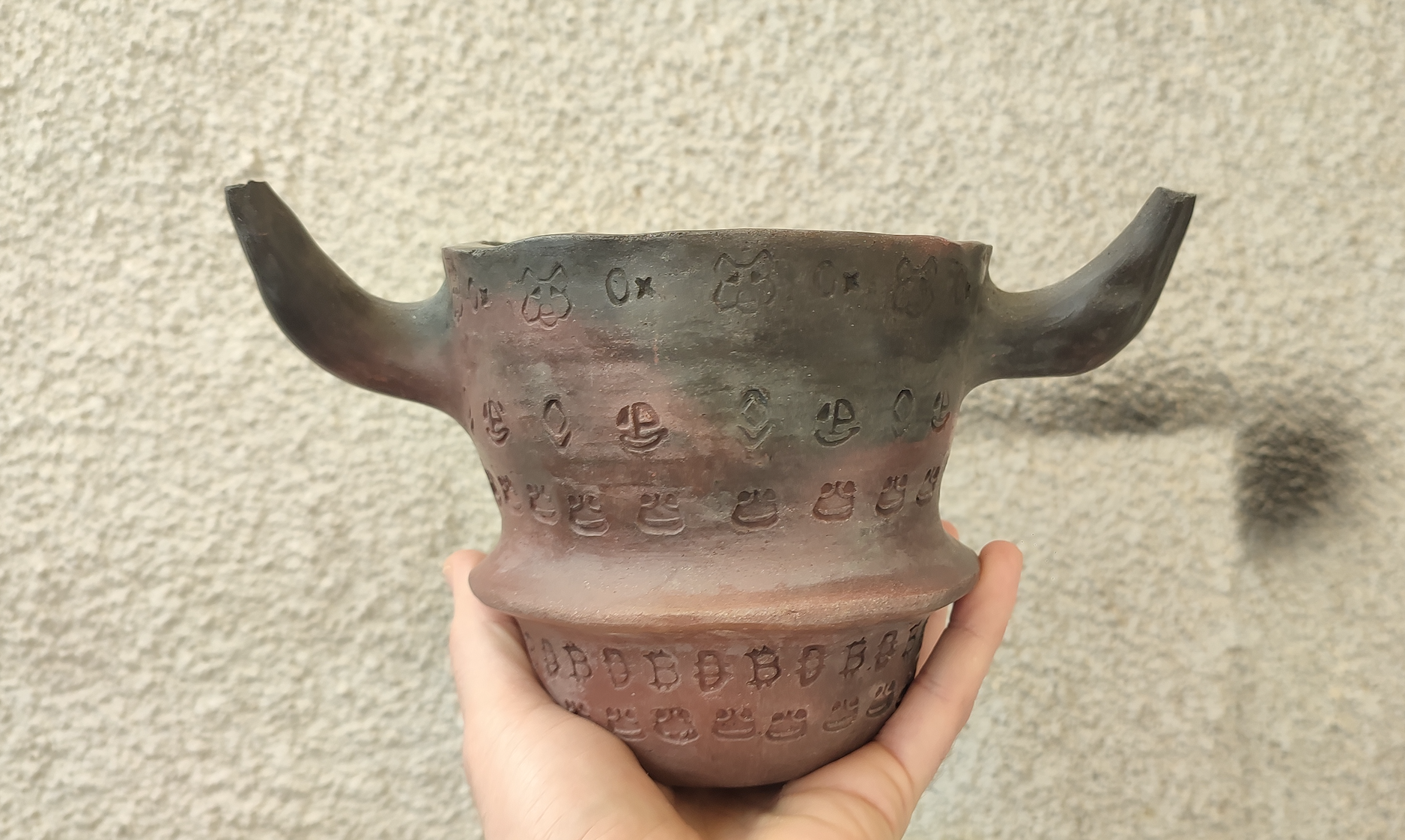 "Bull's cup" use of hand made stamps, fired in an open pit fire/ reduction, neolithic method